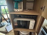 a microwave and a coffee maker in a cabinet
