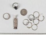 a silver ring, a silver coin, and a silver ring on a white surface