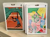 two paintings of tennis players on display on a table
