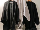 three black and white robes hanging on a wall