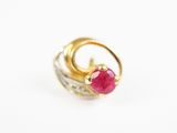 gros plan d'une bague en or avec une pierre en rubis