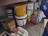 many buckets and containers of paint on the floor