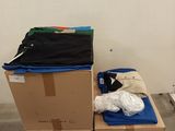 une pile de cartons recouverts de vêtements dans une pièce