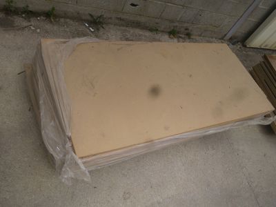 un tas de cartons posé par terre devant un immeuble