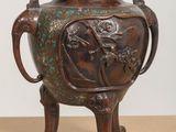 a bronze vase that is on a table