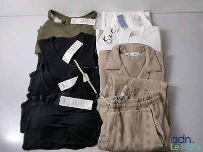 Trois paires de vêtements pour homme sont disposées sur une table