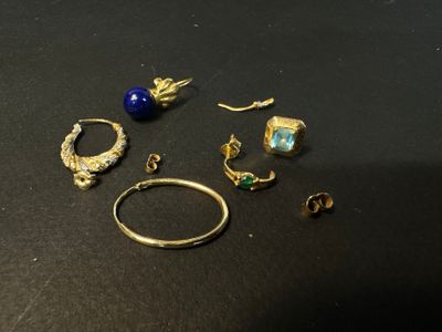 several rings and earrings on a table with a black background