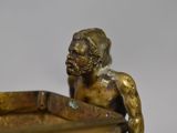 a bronze statue of a man holding a tray