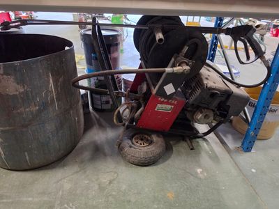 une machine posée sur le sol à côté d'une poubelle