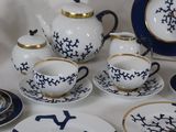 a table with a variety of blue and white dishes and cups