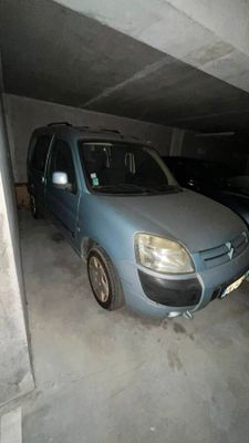 a small blue van parked in a parking garage