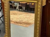 un miroir posé sur le sol devant une commode