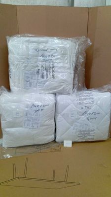 des cartons contenant des matelas sont empilés les uns sur les autres dans un carton