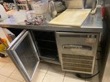 a kitchen with a metal counter and a metal refrigerator