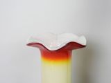 a red and yellow glass vase sitting on a table