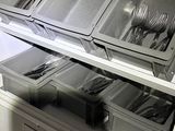 many bins of silverware on the shelves in the kitchen