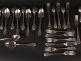 many forks and spoons laid out on the table