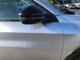 a silver car parked in a parking lot with other cars in the background