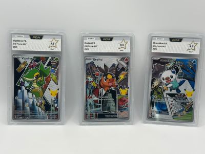 trois cartes à collectionner Pokémon différentes, dans des pochettes en plastique, posées sur une surface blanche