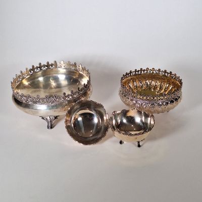 deux plats en argent et un bol en argent posés sur un plateau blanc