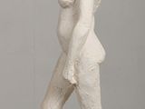 statue of a pregnant woman standing on a pedestal on a table
