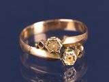 une bague en or sertie de trois diamants sur un fond bleu