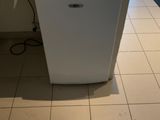 a small white dishwasher sitting on a counter in a kitchen