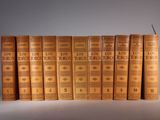six old books are stacked on top of each other in a row
