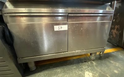 a stainless steel oven sitting on a cart in a kitchen