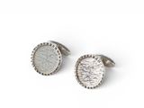 a pair of silver cufflinks on a white background