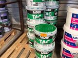 Plusieurs seaux de peinture sont empilés sur une palette dans un entrepôt