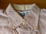 shirt with red and blue stripes on it sitting on a wooden table