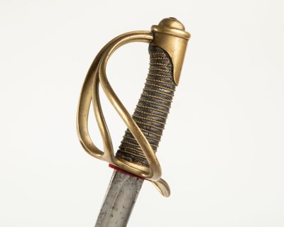 une vieille épée avec un manche en or sur fond blanc