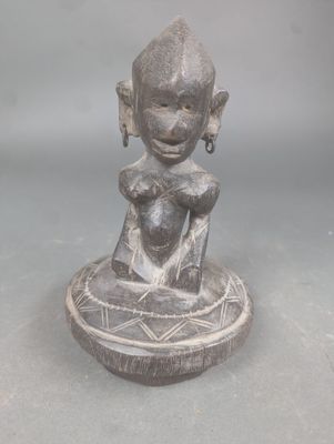 statue représentant une femme tenant un bébé dans un bol posé sur une table