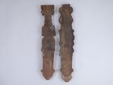 pair of carved wooden figures on a white wall