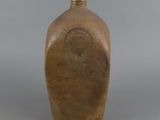 a brown vase with a brown lid sitting on a table
