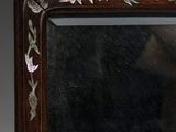 portrait of a man in a black shirt and a brown frame with flowers and leaves