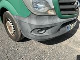 a green van parked in a parking lot next to a building