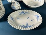 a blue and white table setting with plates, bowls, cups, and spoons