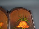 two mirrors with flowers painted on them on the wall