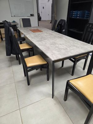des tables et des chaises dans une grande pièce au sol carrelé de blanc