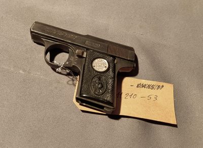 a close up of a gun on a table with a note attached to it