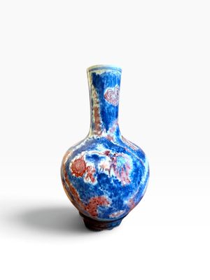 un vase bleu orné d'un motif rouge et blanc