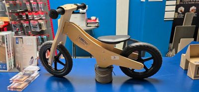 a small wooden bike on a blue table in a store