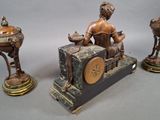 three bronze statues of a woman sitting on a table