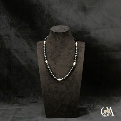 un gros plan d'un collier sur un mannequin, sur fond noir