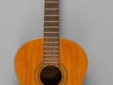 an old wooden guitar sitting on top of a gray surface