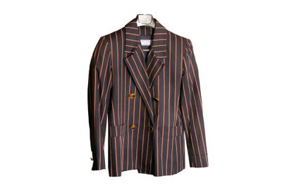 La veste est rayée et comporte un bouton doré sur le revers.