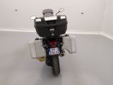 a motorcycle parked in a white room with a license plate on the back of it
