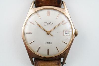 une montre posée sur une surface blanche